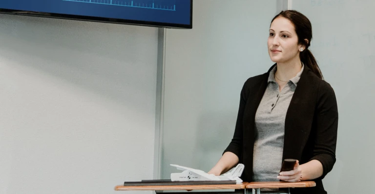 Female professor standing at the front of the classroom