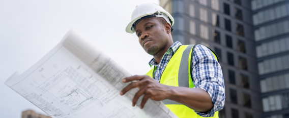 man holding up blue prints